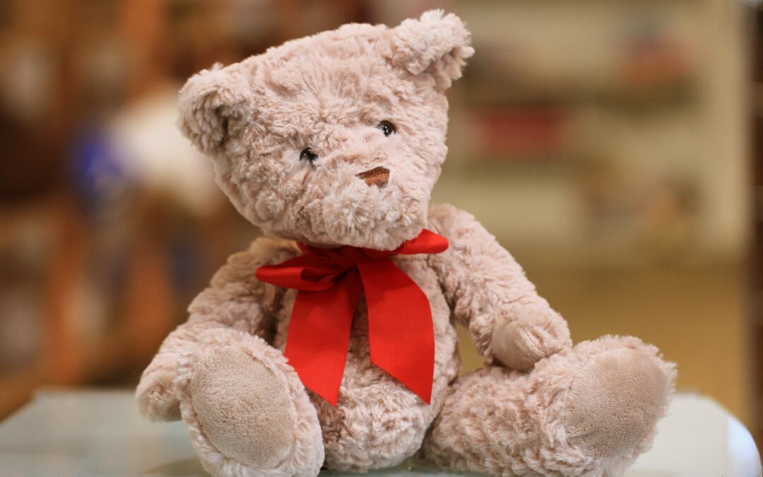 selective focus photo of brown teddy bear with red bow
