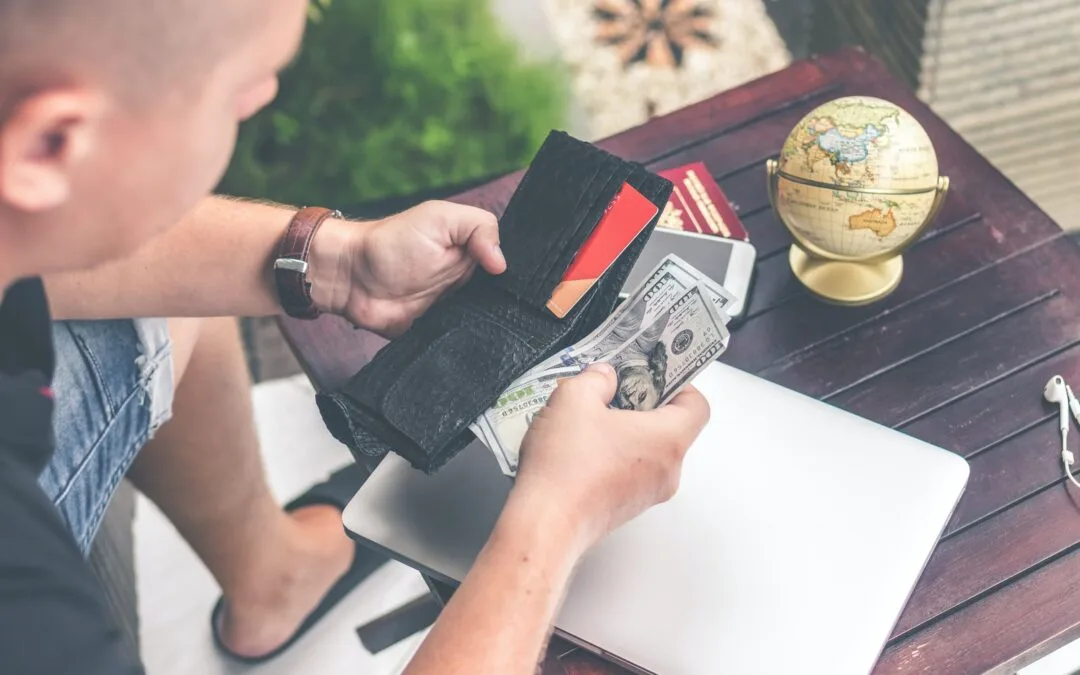 person holding wallet and US dollar bills