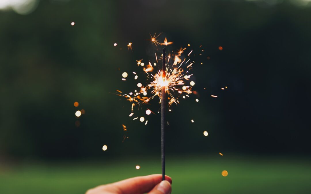 person holding sparkler with bokeh effect